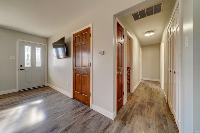 entryway with wood finished floors, visible vents, and baseboards