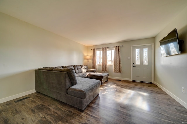 living room featuring visible vents, dark wood-type flooring, and baseboards