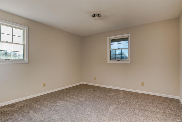 empty room featuring carpet flooring, baseboards, and visible vents