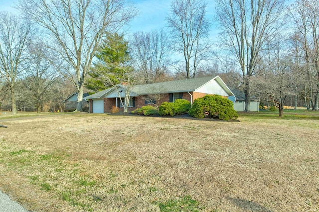 ranch-style home with a front yard, brick siding, and an attached garage