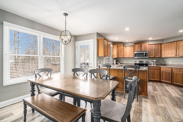 dining area featuring recessed lighting, light wood-type flooring, baseboards, and a textured ceiling