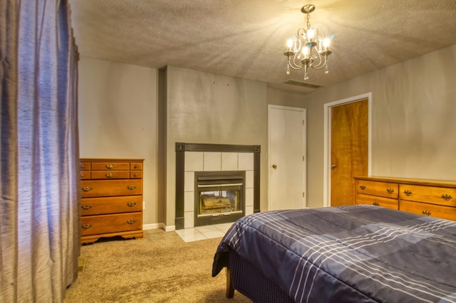 bedroom with carpet, visible vents, an inviting chandelier, a fireplace, and a textured ceiling