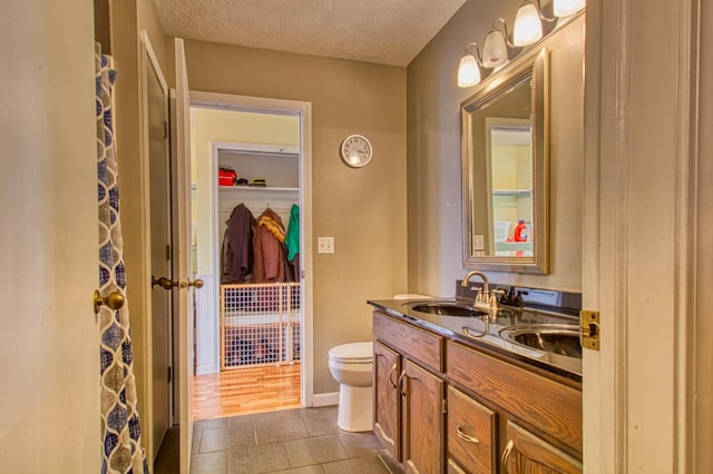 bathroom with tile patterned flooring, toilet, vanity, a shower with curtain, and a textured ceiling