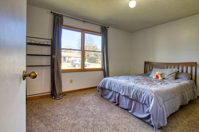 carpeted bedroom featuring baseboards and a textured ceiling