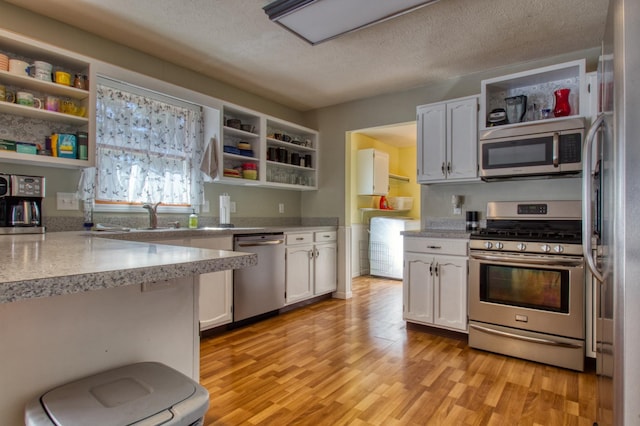 kitchen with open shelves, stainless steel appliances, and white cabinetry