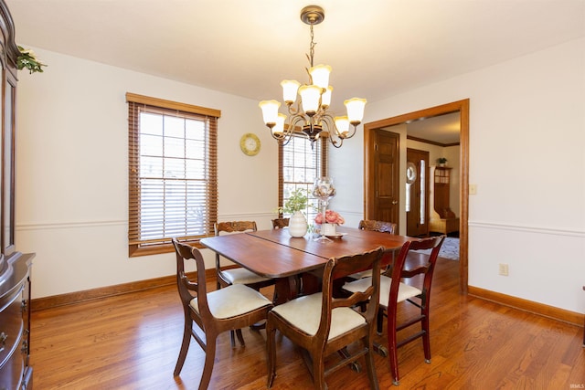 dining area with light wood-style floors, baseboards, and a chandelier