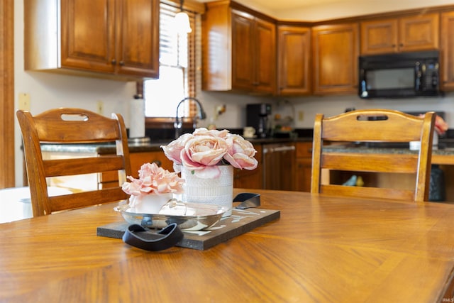 kitchen with brown cabinets, black microwave, and butcher block countertops