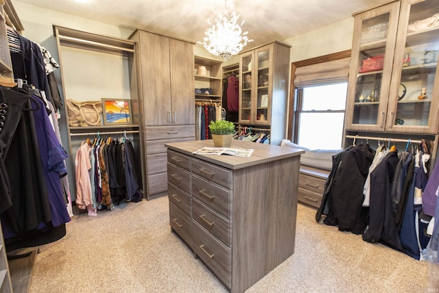 walk in closet with a chandelier and light carpet