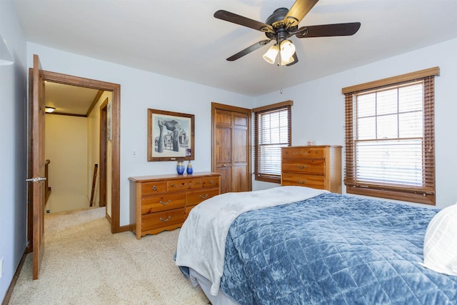 bedroom featuring ceiling fan, baseboards, and light carpet