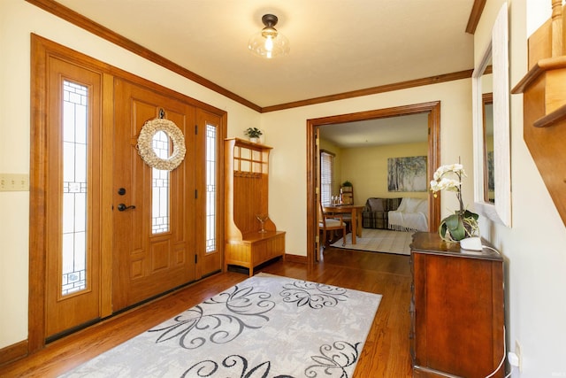 foyer with wood finished floors, baseboards, and ornamental molding