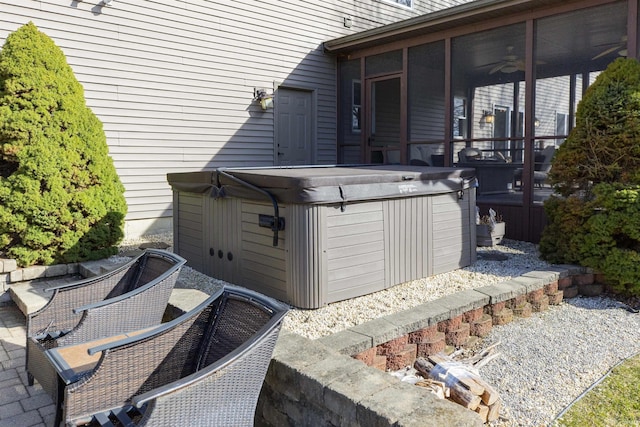 view of patio / terrace with a sunroom and a hot tub