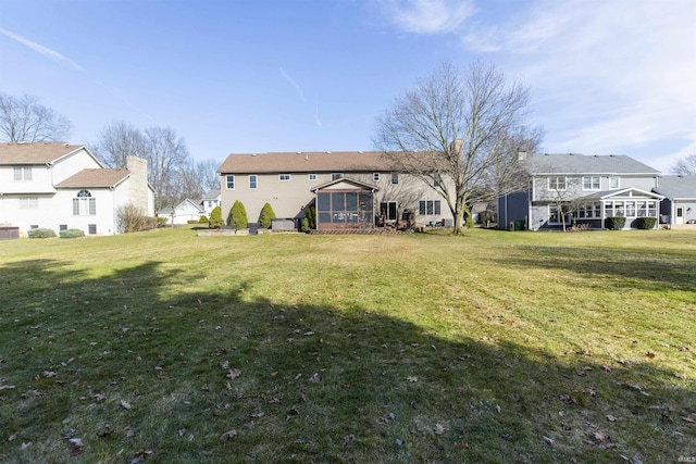 back of property featuring a residential view and a lawn