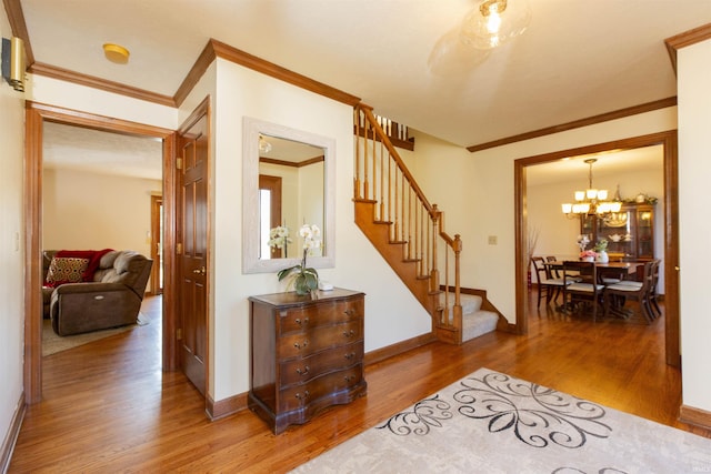 interior space with stairway, baseboards, light wood-style flooring, and crown molding