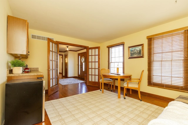 interior space featuring wood finished floors, visible vents, french doors, and baseboards