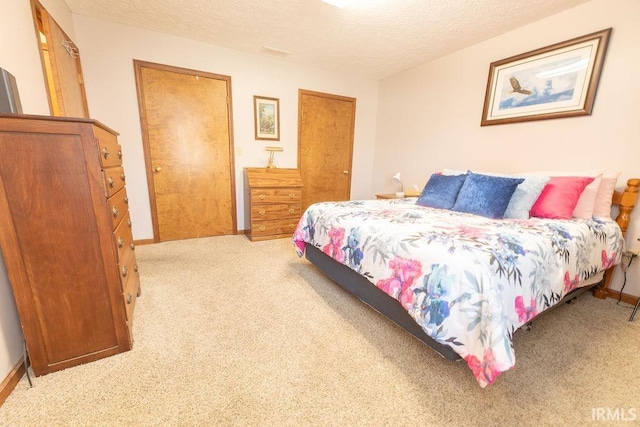 bedroom with baseboards, carpet floors, and a textured ceiling