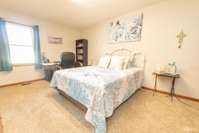 bedroom with carpet flooring, baseboards, and a textured ceiling