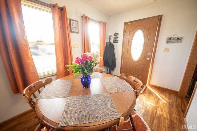 dining space featuring wood finished floors and baseboards