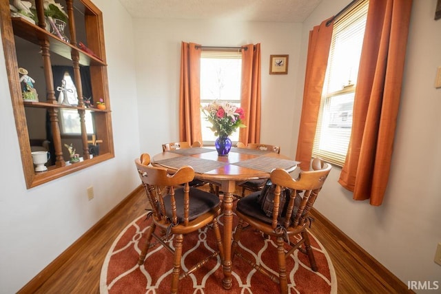 dining space featuring baseboards and wood finished floors