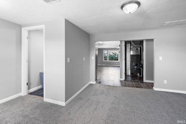 interior space featuring carpet flooring, baseboards, visible vents, and a textured ceiling