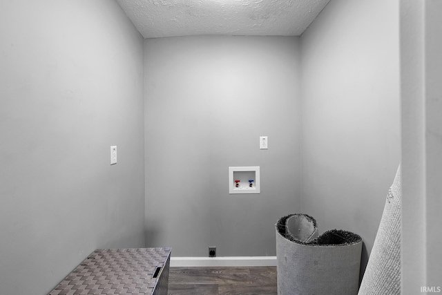 laundry area with dark wood-type flooring, laundry area, hookup for a washing machine, hookup for an electric dryer, and a textured ceiling