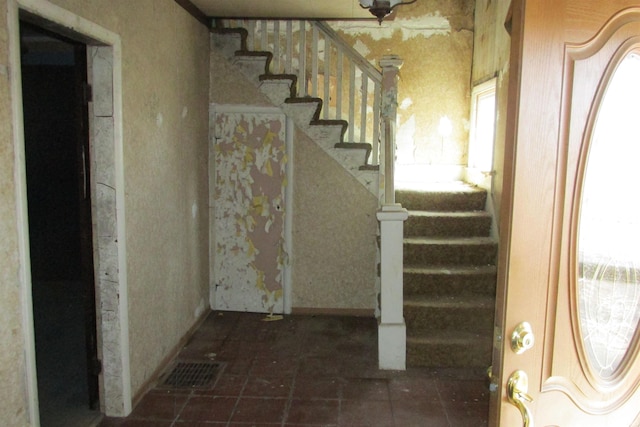 stairway with visible vents and brick floor