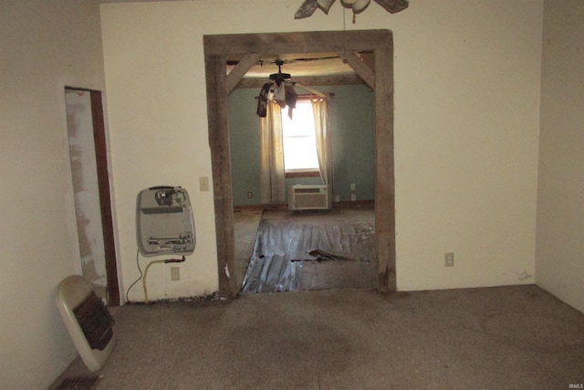 spare room featuring heating unit, an AC wall unit, and ceiling fan