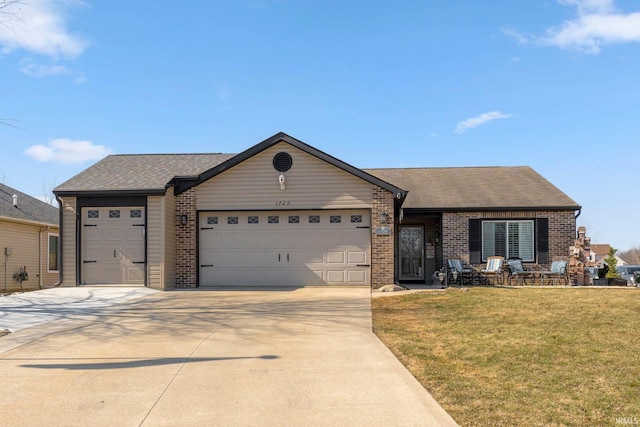 single story home featuring brick siding, a front lawn, roof with shingles, a garage, and driveway