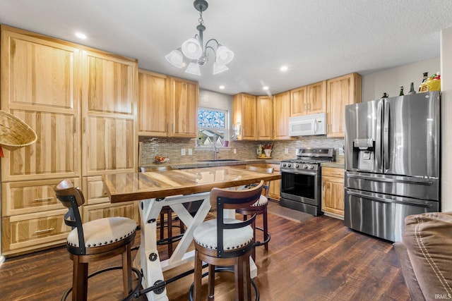 kitchen featuring dark wood-style floors, light brown cabinets, stainless steel appliances, and a sink