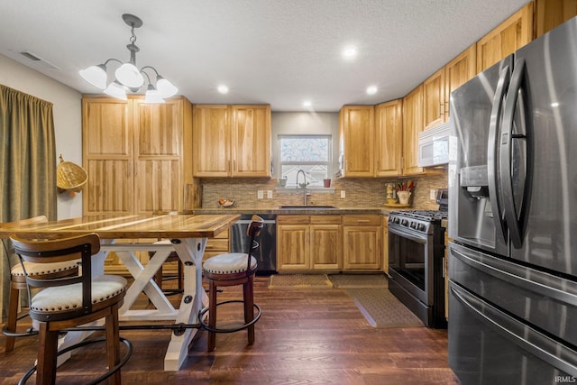 kitchen with visible vents, decorative backsplash, appliances with stainless steel finishes, dark wood-style floors, and a sink