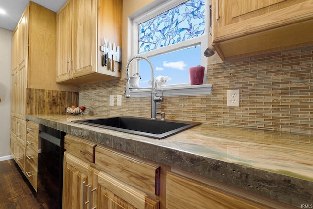 kitchen with a sink, backsplash, dishwasher, and light brown cabinetry