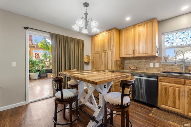 kitchen featuring dark wood-type flooring, a sink, backsplash, baseboards, and dishwasher