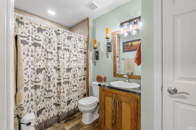 full bath with visible vents, curtained shower, toilet, wood finished floors, and vanity