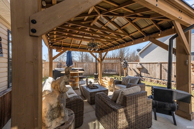 view of patio / terrace featuring a gazebo, an outdoor living space, and a fenced backyard