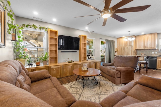 living room with recessed lighting, visible vents, dark wood finished floors, and ceiling fan with notable chandelier