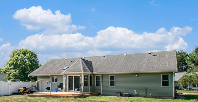 rear view of property with a yard, a deck, a fenced backyard, and an attached garage