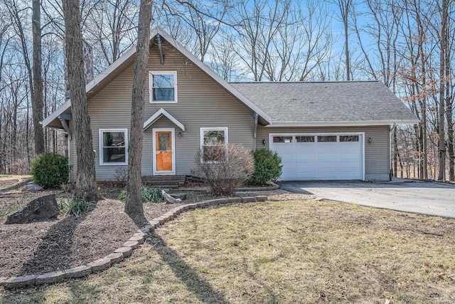 view of front of house featuring a garage, concrete driveway, a front yard, and a shingled roof