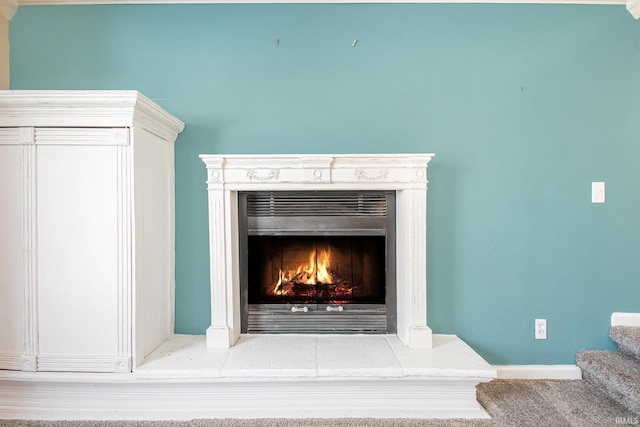 room details featuring a warm lit fireplace