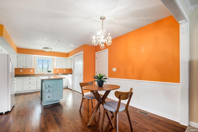 kitchen featuring visible vents, white cabinetry, freestanding refrigerator, and dark wood-type flooring