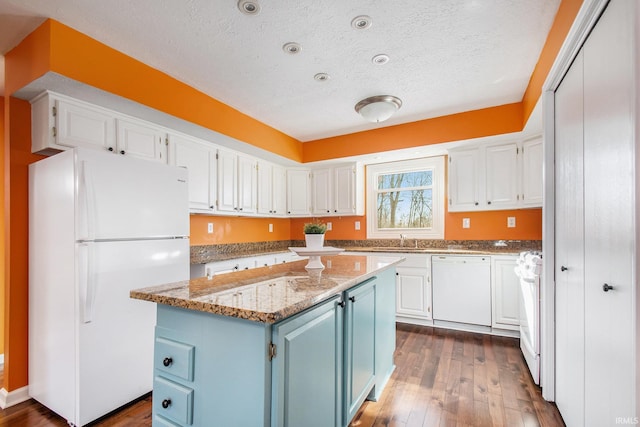 kitchen featuring blue cabinetry, white appliances, and white cabinetry