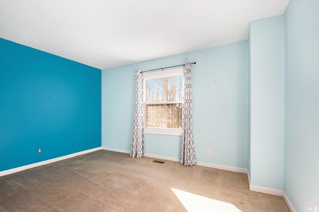 empty room with visible vents, baseboards, and carpet floors