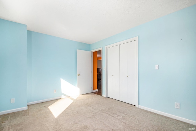 unfurnished bedroom with a closet, baseboards, and carpet flooring