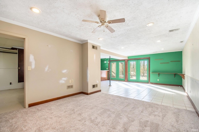 tiled empty room with carpet, visible vents, and a textured ceiling