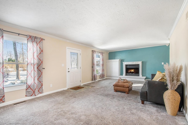 living area featuring ornamental molding, a fireplace, a textured ceiling, and carpet floors