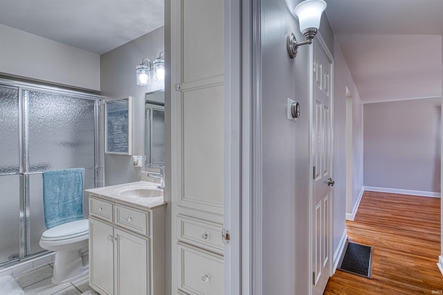 bathroom with vanity, a shower stall, toilet, and visible vents