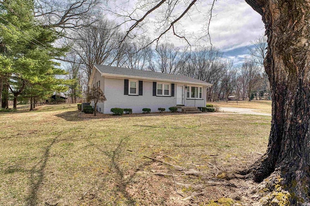 single story home with brick siding, central air condition unit, and a front lawn