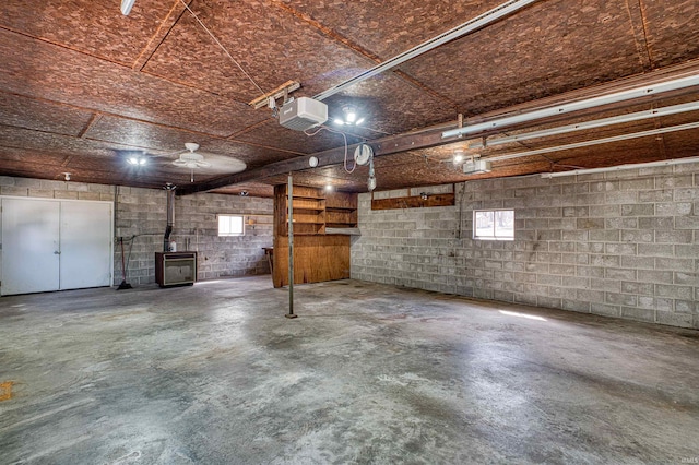 parking deck featuring concrete block wall, a garage door opener, and a wood stove