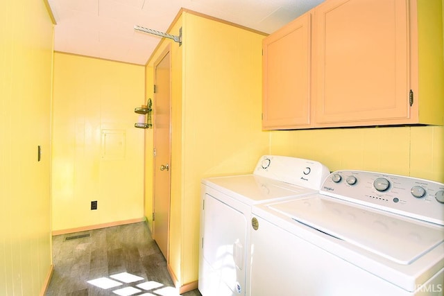 laundry room with washer and dryer, visible vents, cabinet space, and light wood-type flooring