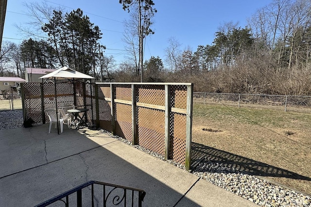 view of gate featuring a patio area, a yard, and a fenced backyard