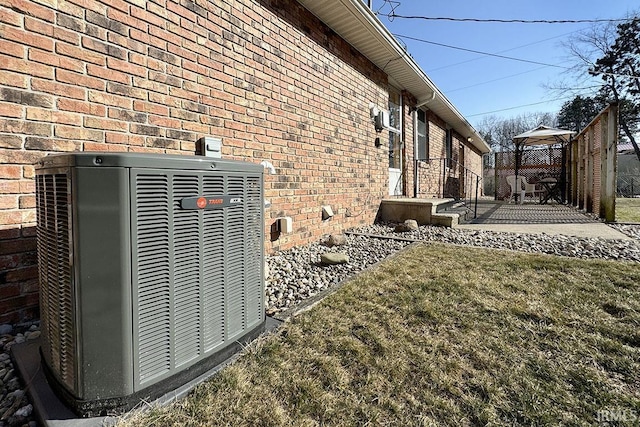 details featuring brick siding and central air condition unit