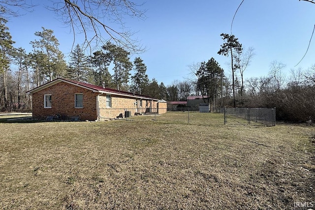 exterior space with a yard, brick siding, and fence